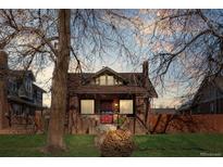 Brick home with a charming front porch and landscaped lawn at 3311 W Clyde Pl, Denver, CO 80211