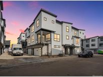 Modern townhome showcasing contemporary design with stone accents and a clean, neutral color palette at dusk at 2046 S Holly St # 1, Denver, CO 80222