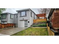 Charming home with modern garage door, landscaped yard and a covered patio at 20 S Harrison St, Denver, CO 80209