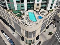 Aerial view of a rooftop pool and jacuzzi, surrounded by lounge chairs and tables at 2001 Lincoln St # 2420, Denver, CO 80202