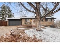 Charming brick home with a well-manicured front yard and attached garage at 977 S Reed St, Lakewood, CO 80226