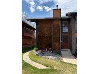 Charming two-story home featuring unique cedar shake siding and a well-manicured front yard with rock landscaping at 1273 S Crystal Way, Aurora, CO 80012