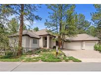 Beautiful beige home with a three car garage and well-maintained front yard, creating excellent curb appeal at 474 Silbrico Way, Castle Rock, CO 80108