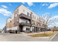 Modern multi-level townhome with a private balcony, stone accents, and manicured landscaping at 2622 W 24Th Ave # 4, Denver, CO 80211