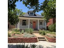 Charming home featuring a cozy front porch and a well-maintained, landscaped front yard at 613 S Logan St, Denver, CO 80209