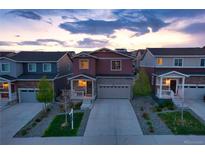 Charming two-story home with a well-manicured front yard and a driveway leading to a two-car garage at 5311 Blue Lunar Ln, Castle Rock, CO 80104