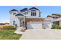 Charming two-story home with blue siding, stone accents, and a well-manicured front yard at 6739 Blue Spruce St, Frederick, CO 80530