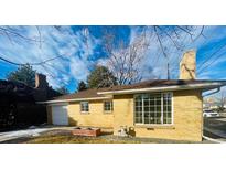 Ranch style home with attached garage and landscaped yard at 799 N Holly St, Denver, CO 80220