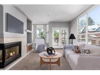 Bright living room features a fireplace, plush carpet, and a balcony with views at 1521 Vine St # 108, Denver, CO 80206
