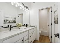 Bright bathroom features double vanity, modern fixtures, and tub/shower combo at 42979 Colonial Trl, Elizabeth, CO 80107
