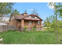 Brick single-Gathering home with a covered front porch and overgrown lawn at 2701 W Mississippi Ave, Denver, CO 80219