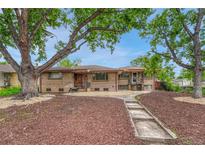 Charming brick duplex with mature trees, rock landscaping, and a walkway leading to the front entrance at 3854 Perry St, Denver, CO 80212