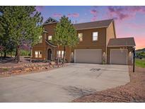 Charming two-story home with a three-car garage, basketball hoop, stone accents, and professionally landscaped front yard at 1822 Painter Dr, Monument, CO 80132
