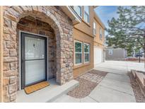 Inviting front entrance features a unique stone archway and well-maintained landscaping, leading to the front door at 1822 Painter Dr, Monument, CO 80132