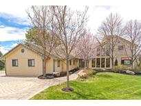 Inviting home exterior features a well-manicured lawn, tasteful landscaping, and a circular brick driveway at 5553 S Chester Ct, Greenwood Village, CO 80111