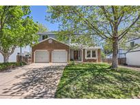Charming two-story home featuring brick accents, a two-car garage, and a well-maintained front lawn at 5046 S Evanston St, Aurora, CO 80015