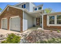 Inviting front entrance featuring a two-car garage and a cozy covered porch at 5046 S Evanston St, Aurora, CO 80015