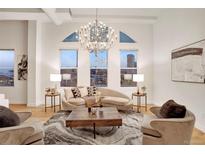 Bright living room featuring a modern chandelier, large windows, and comfortable seating area with city views at 1521 Central St # 3C, Denver, CO 80211