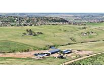 Expansive aerial view of equestrian estate with barns, pastures, and stunning mountain views at 1705 Outter Marker Rd, Castle Rock, CO 80108