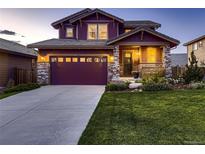 Charming two-story home featuring a well-manicured lawn, stone accents, and a spacious driveway leading to a two-car garage at 10167 Nadine Ave, Parker, CO 80134