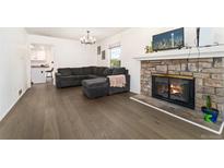 Inviting living room featuring a stone fireplace, comfortable seating, and hardwood flooring at 1370 S Idalia St # A, Aurora, CO 80017