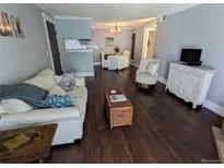 Cozy living room featuring hardwood floors, comfortable seating, and an open view into the dining area at 1863 S Pitkin Cir # B, Aurora, CO 80017