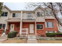 Inviting townhome featuring a brick facade, balcony, and well-maintained landscaping and pleasing curb appeal at 4504 S Cimmarron Cir # D, Aurora, CO 80015