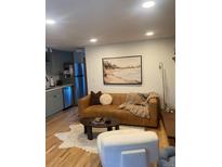 Inviting living room featuring a leather sofa, stylish decor, and an open layout connecting to the kitchen at 155 S Pennsylvania St # 209, Denver, CO 80209
