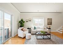 Bright living room features a large window, hardwood floors, and comfortable seating arrangement at 3402 N Clayton St, Denver, CO 80205