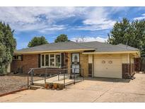 Charming brick ranch-style home featuring a well-maintained front yard and attached one car garage at 2692 S Osceola St, Denver, CO 80219
