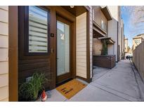 Inviting front entrance featuring a modern door, potted plants, and a welcoming doormat that says 'Hey, Hi, Hello!' at 4440 Tennyson St # 4, Denver, CO 80212