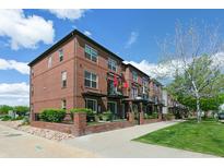 Beautiful brick townhomes featuring balconies, black railings, and lush green landscaping at 4181 W 118Th Pl, Westminster, CO 80031