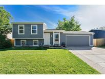 Charming two-story home with manicured lawn, gray siding and a two car garage on a sunny day at 19523 E Buchanan Pl, Aurora, CO 80011