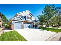 Charming two-story home with a three-car garage, beautiful blue siding, and a well-manicured lawn at 22685 E Calhoun Pl, Aurora, CO 80016