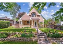 Charming two-story home with a landscaped yard, stone garden bed, and a welcoming front porch at 1459 S Elizabeth St, Denver, CO 80210