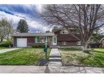 Charming two-story home with a well-maintained front yard, walkway, and wood facade under a partly cloudy sky at 7425 S Dexter St, Centennial, CO 80122