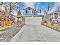 Charming two-story home featuring a well-maintained lawn and a spacious two car garage at 16332 Bluebell Pl, Parker, CO 80134