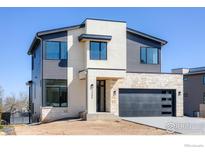 Modern two-story home featuring stone accents, gray siding, and a sleek black garage door at 2305 Glacier Ct, Lafayette, CO 80026