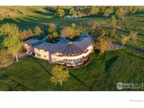 Expansive single-story house with a circular design, set amidst lush green lawns and mature trees at 640 S 68Th St, Boulder, CO 80303