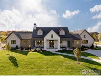 Stunning modern farmhouse exterior with a large front yard and walkway at 6816 Goldbranch Dr, Niwot, CO 80503