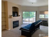 Cozy living room features a fireplace, built-in shelves, and access to a patio with sliding glass doors at 560 Mohawk Dr # 35, Boulder, CO 80303