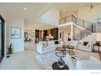 Spacious open-concept living room flows into a modern kitchen with stylish decor at 923 Saint Andrews Ln, Louisville, CO 80027