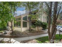 Tan two-story townhome with landscaping, walkway, and balcony at 4837 White Rock Cir # G, Boulder, CO 80301