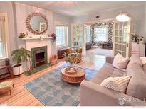 Cozy living room featuring a decorative fireplace, sunburst mirror, and comfortable seating area at 1515 E 8Th Ave # 1, Denver, CO 80218