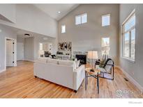 Spacious living room featuring hardwood floors, vaulted ceilings, and a cozy fireplace at 958 Eldorado Ln, Louisville, CO 80027