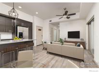 Open living room and kitchen with modern appliances and island at 2445 Junction Pl # 206, Boulder, CO 80301