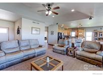Cozy living room with ceiling fan, neutral tones, and seamless flow into kitchen, perfect for modern living at 11499 County Road 40.5, Platteville, CO 80651