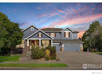 Charming two-story home with a three-car garage, lush landscaping, and a welcoming brick entrance at 2841 Ironwood Cir, Erie, CO 80516