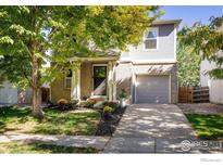Charming two-story home featuring a well-maintained lawn, inviting entryway, and attached garage at 3674 Dexter St, Denver, CO 80207