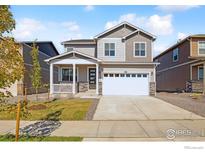Charming two-story home with a welcoming front porch and a well-maintained lawn at 6543 12Th St, Frederick, CO 80530